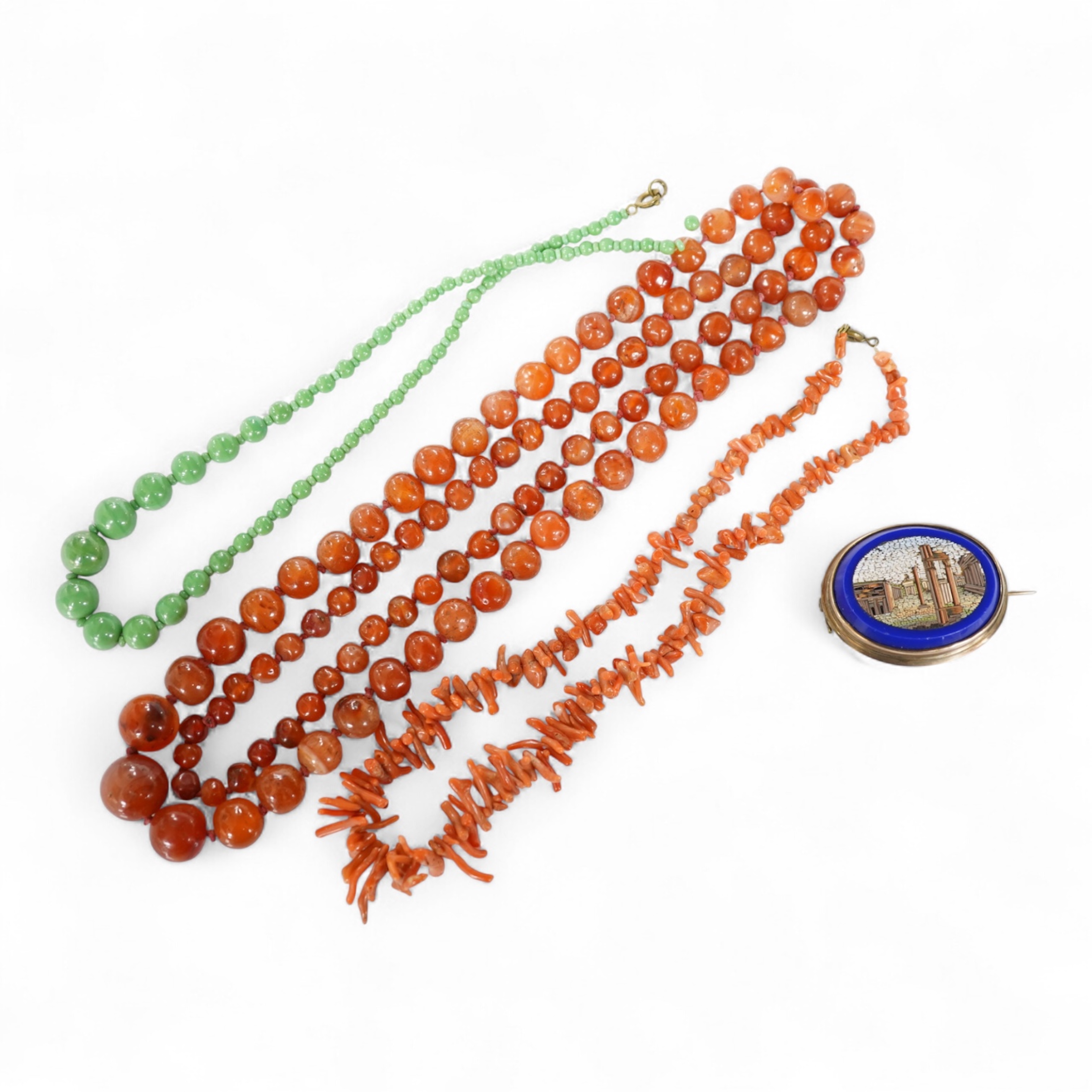 A micromosaic brooch and a group of bead necklaces, comprising: a micromosaic brooch depicting the Forum, length 4.6cm; together with a carnelian bead necklace; a coral branch necklace; and a green glass bead necklace